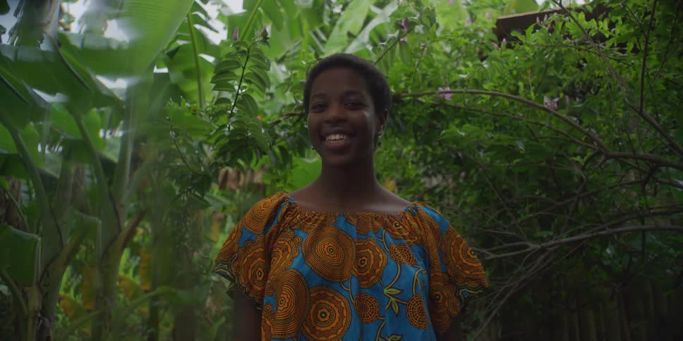 Woman in dress with happy facial expression in outdoor tropical environment