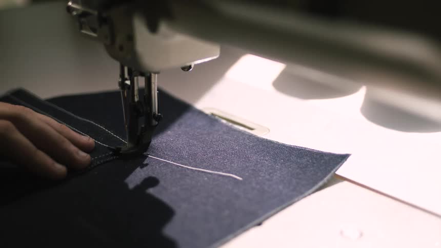 A person using a sewing machine to stitch fabric