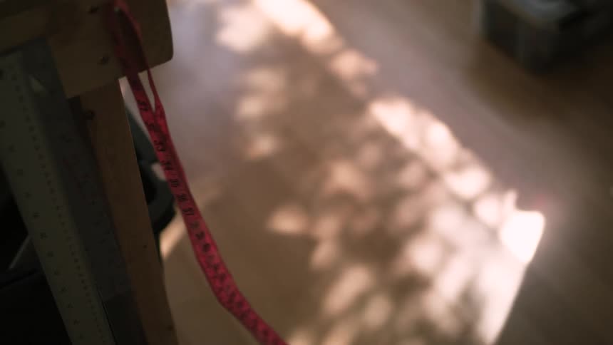 A red measuring tape blowing in the wind