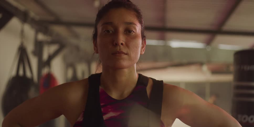 Portrait of a woman with a determined expression at a martial arts gym