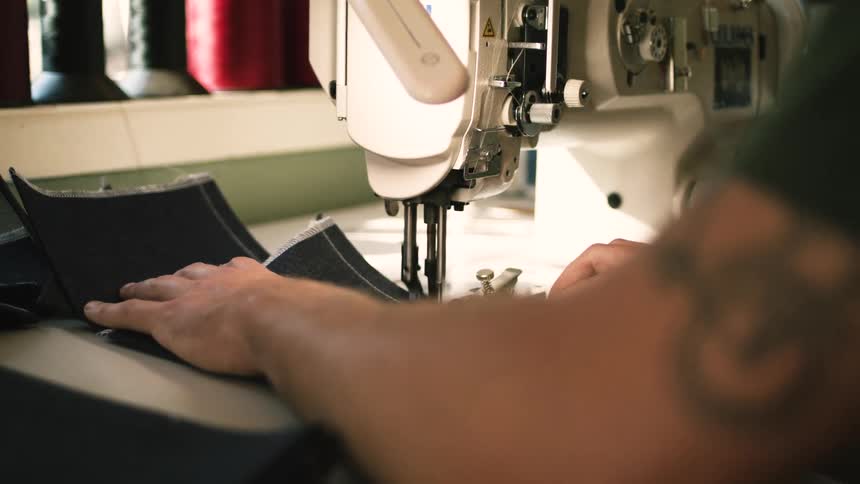 A man sewing fabrics on a sewing machine