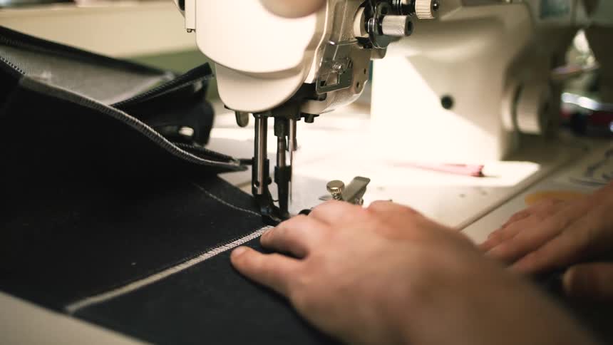 Pair of hands sewing a fabric