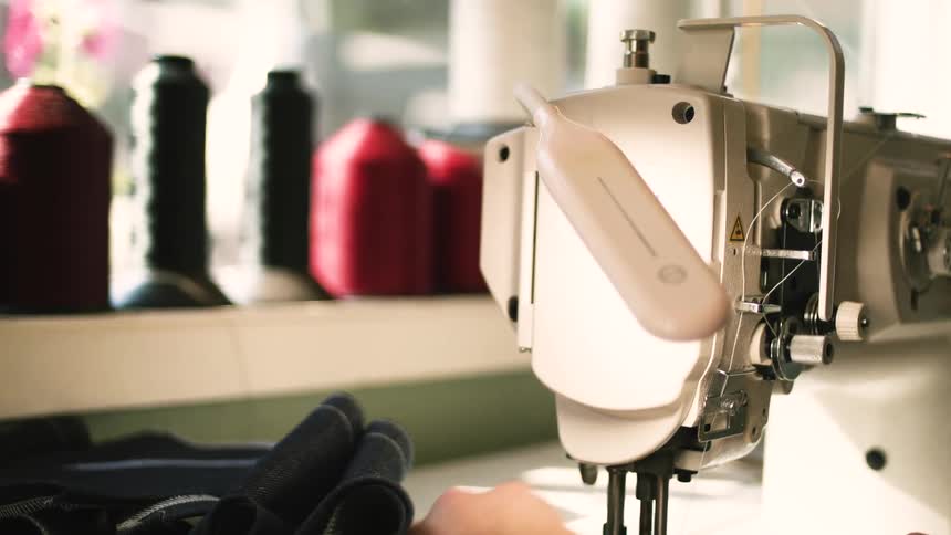 Man uses a sewing machine to work on a sewing project