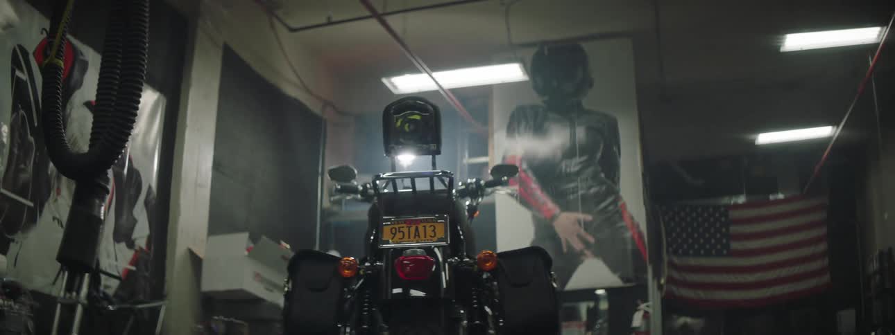 Motorcycle stands in a room among motorcycle equipment and motorcycle themed items