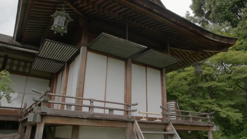 Trees surround this house with a wooden staircase in front