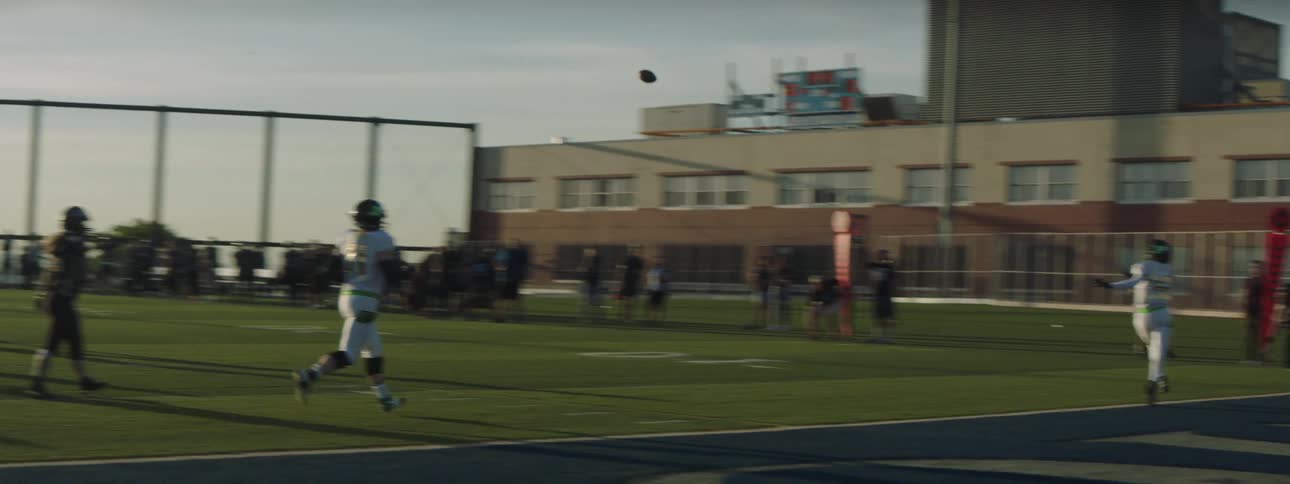 A football field bustling with players energetically participating in a game during the day passing the ball around as they play