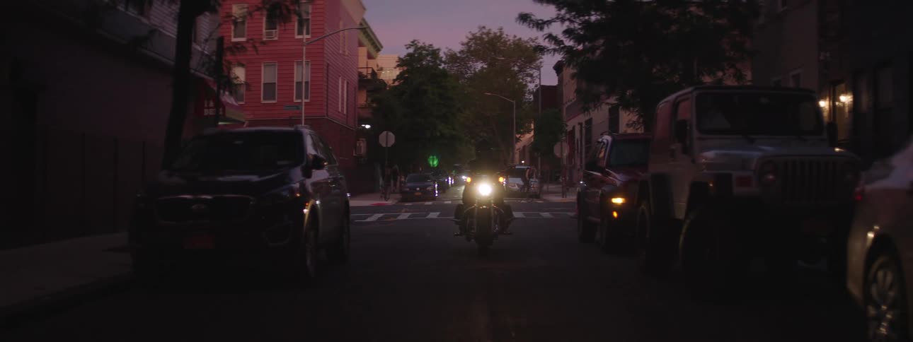 Motorcycle with headlights on traveling on an urban road
