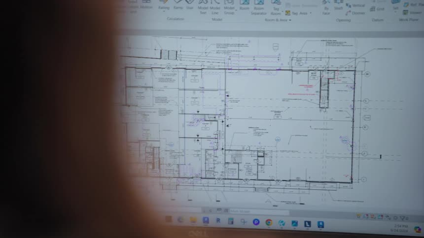 Person interacting with a monitor screen displaying a project