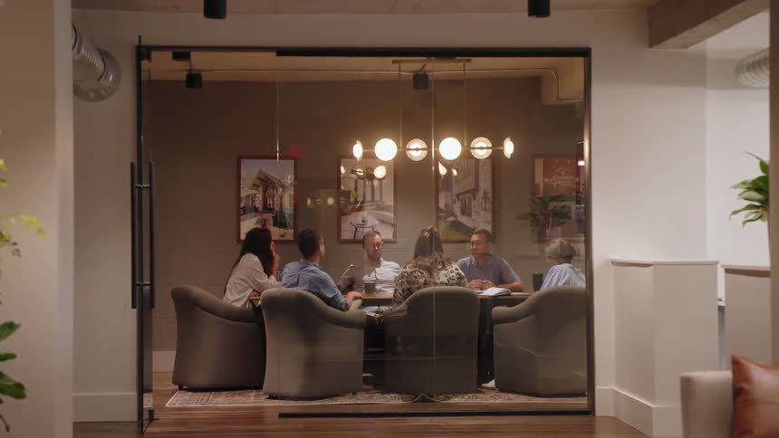 People in a room sitting at an office table in a meeting