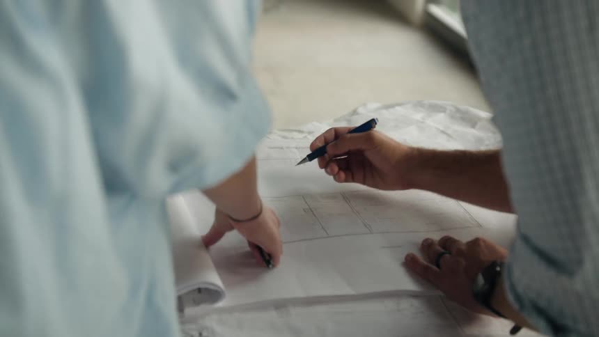Person handling a straight line on a large project paper on a table covered in fabric