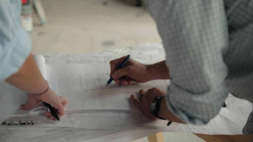 Arm of an engineer with a pen checking a project