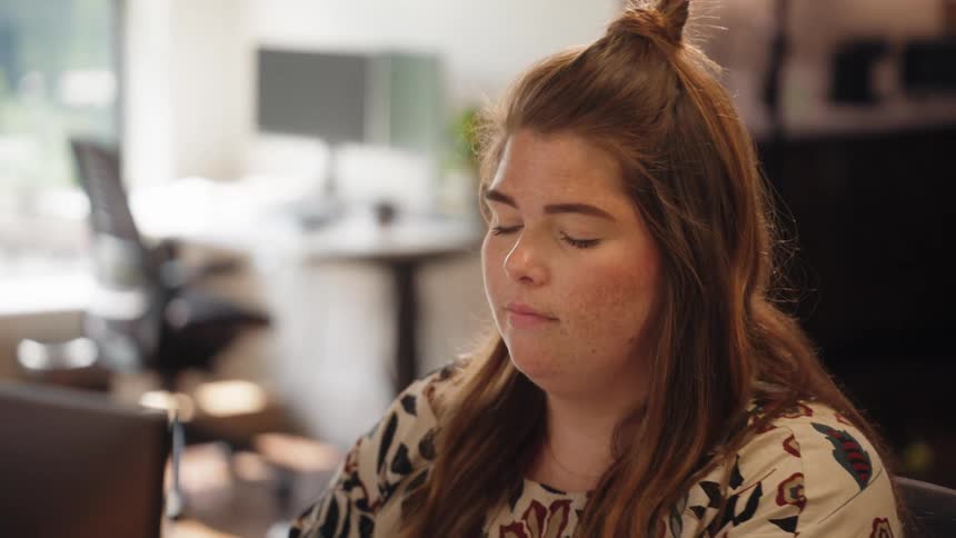 A woman is typing on her keyboard in the office