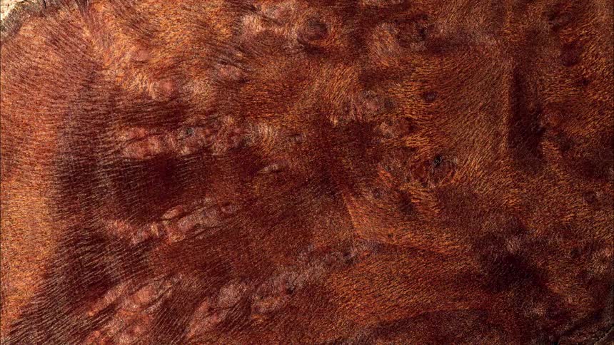 Golden brown sandy mixture flows over a textured surface creating small rippling waves