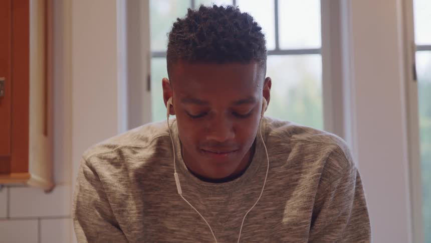 Young man with eyes closed wearing wired headphones