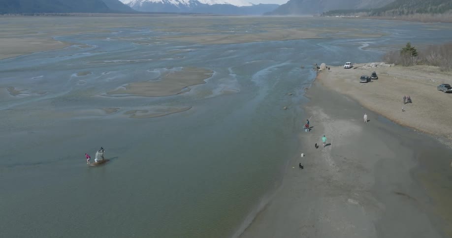 A group of people are catching fish along the rivers edge