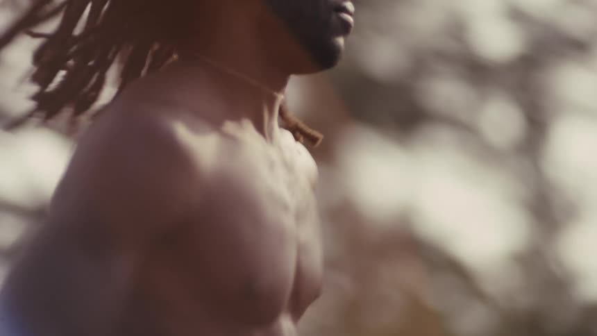 A black man is running outdoors on a rural road