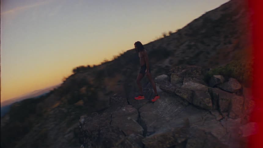 A man is standing by the cliff of a tall mountain