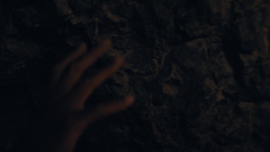 A hand gently touching a rock