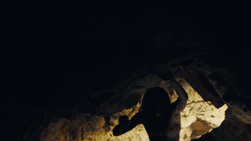 A man walks into the dark cave