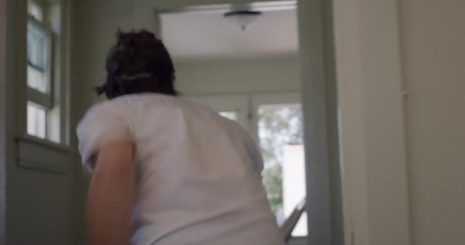A person stands up and runs quickly through a house