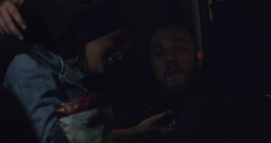 A woman and a man smiling together while eating a snack