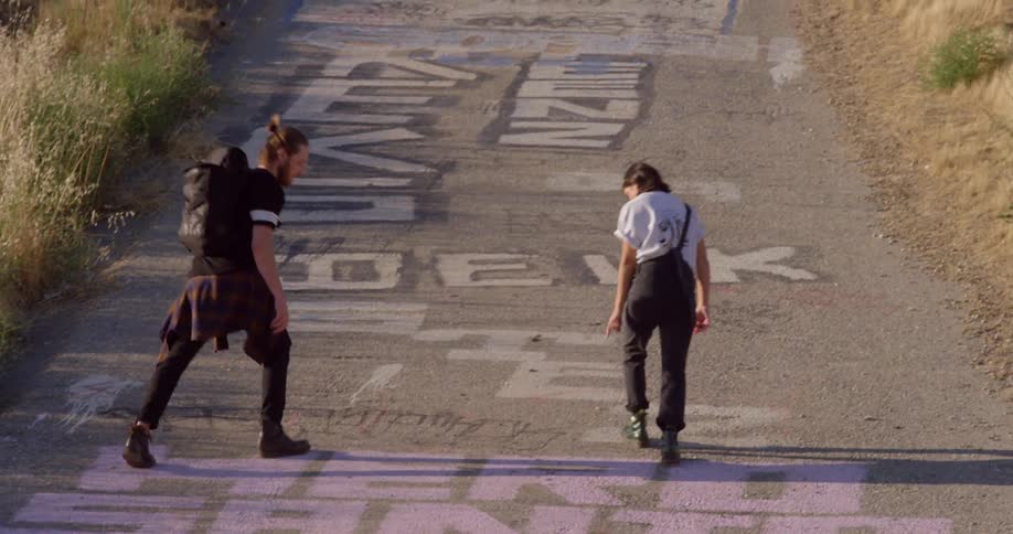 Two people walking up a hill in the late afternoon