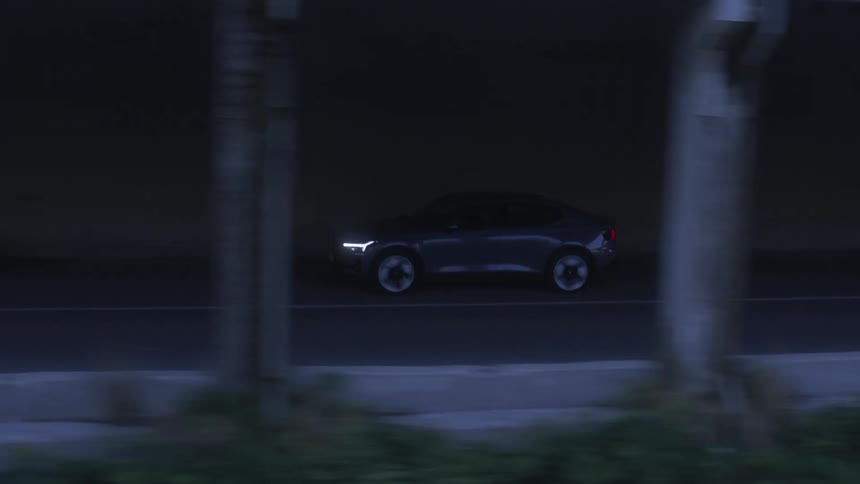 Unused sedan car passing over an overpass on a paved road on the edge of a mountain