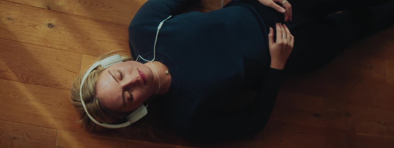 Blonde woman lying down with headphones