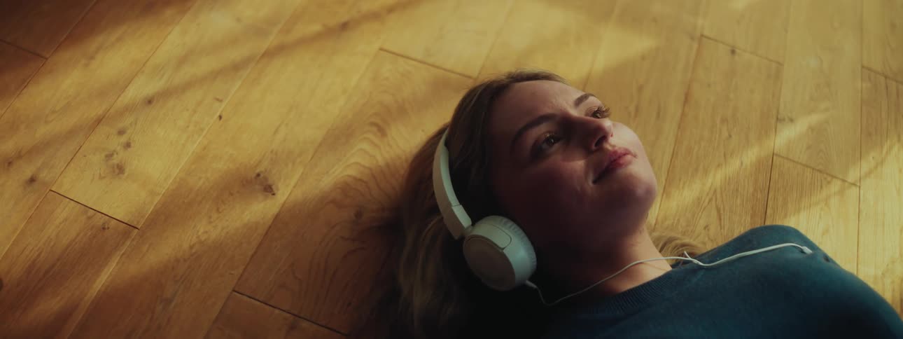 Woman with white headphones lying down
