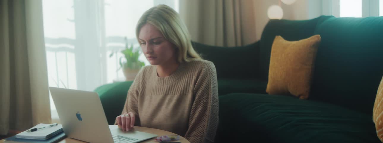 Woman sitting in living room interacting with a laptop
