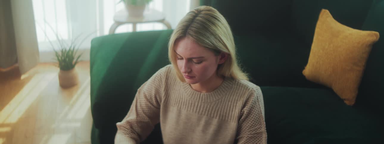 Woman sitting in living room concentrating