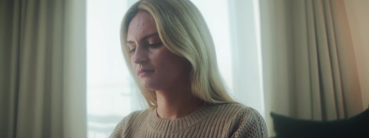 A woman focused inside a brightly lit room