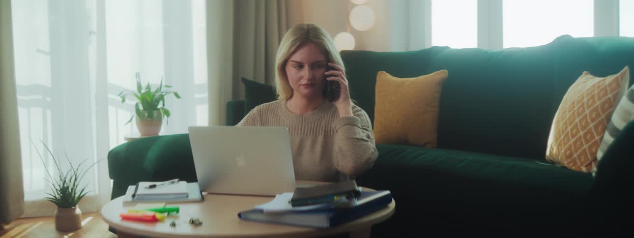 Woman on the phone and interacting with a laptop