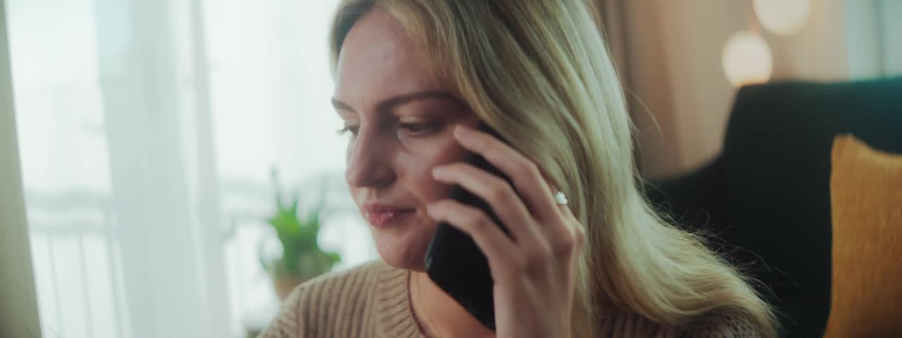 A woman talking on the phone and writing in a notebook