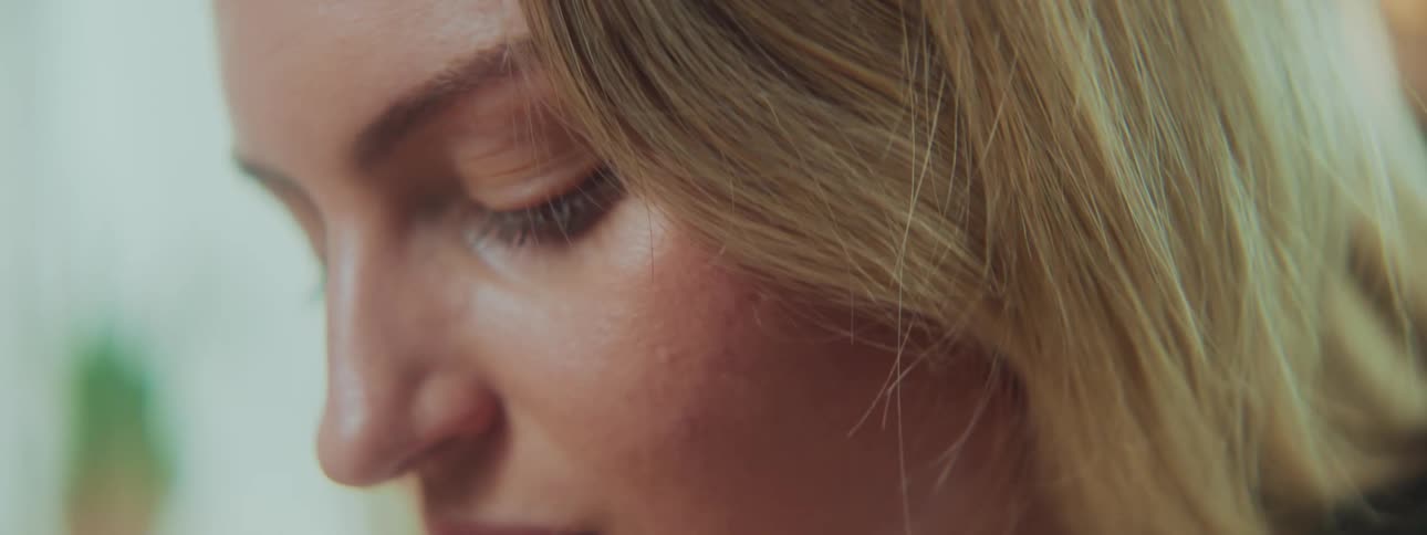 A woman is looking down and moving her head