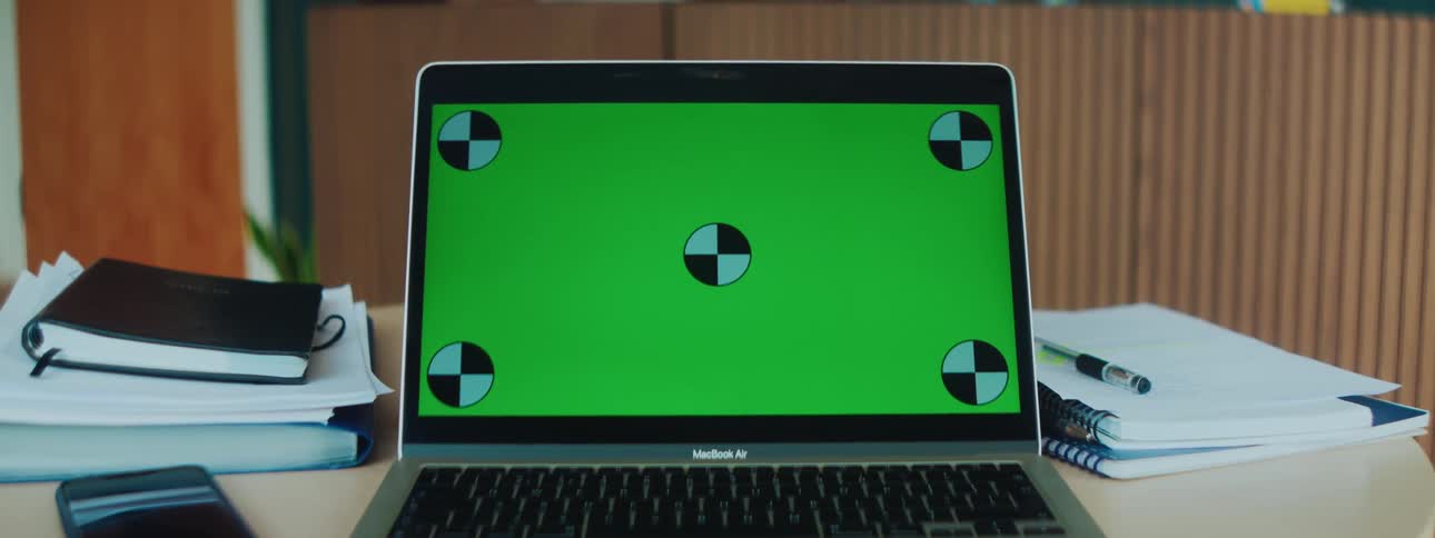 A laptop screen with a green background and five circles on it in black and white