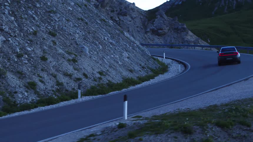 A car drives around the winding road on the mountain