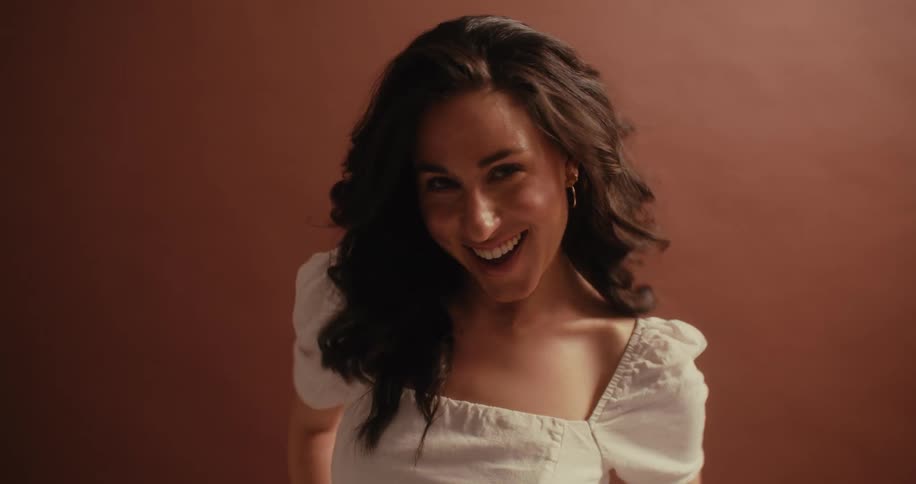 Smiling woman against a brown wall