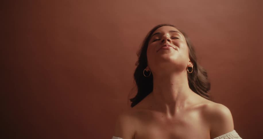 Woman with happy facial expression posing in a studio