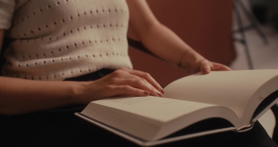 Sitting woman slips through a hardback book