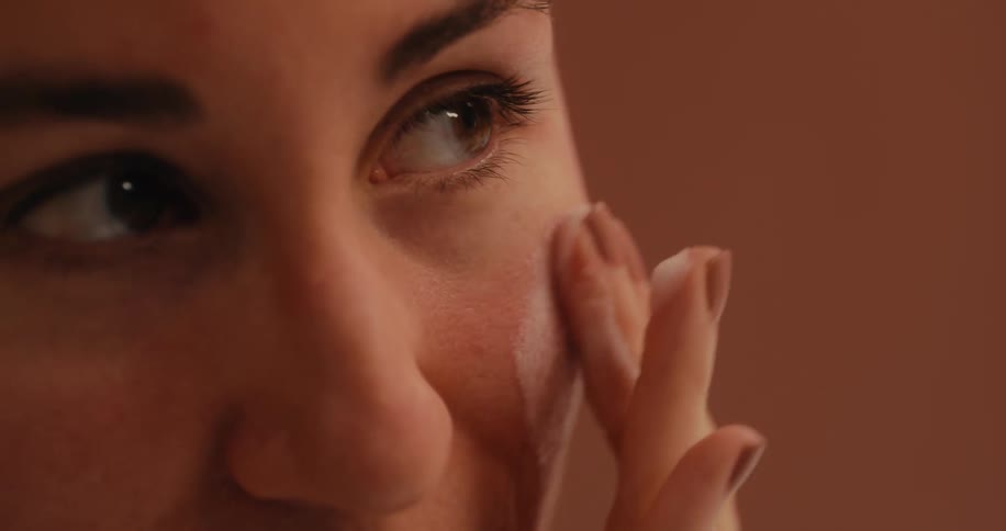 Woman carefully lathers up her cheek