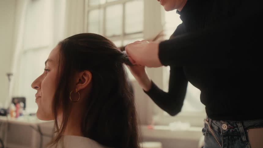 A hairdresser styling a womans hair