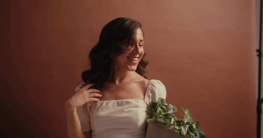 A woman holding a potted plant smiling and very happy
