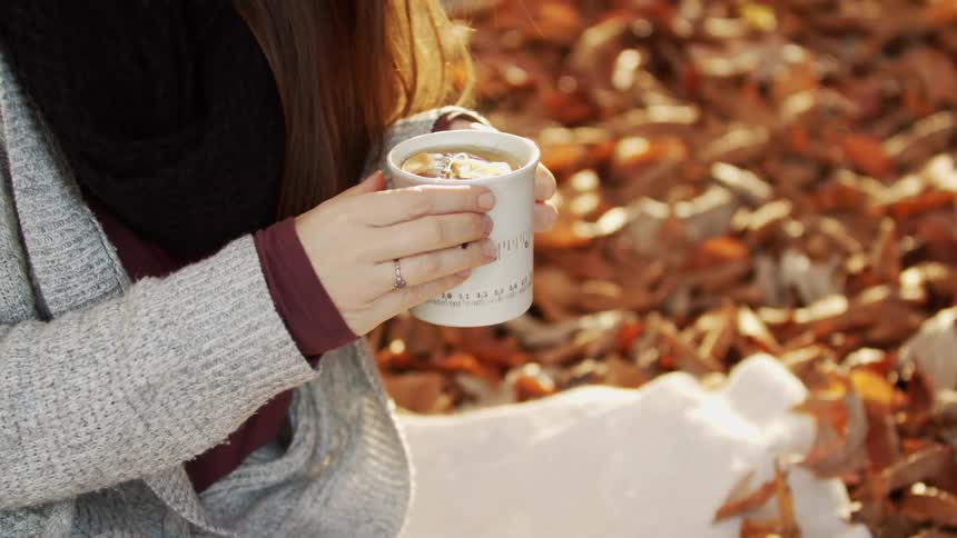 Woman outdoors holding a cup of tea