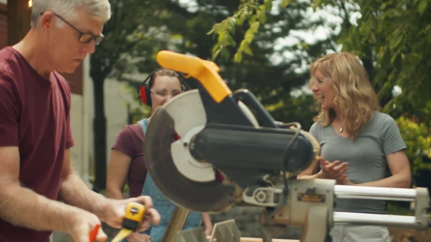 A man measures wood getting ready to cut it