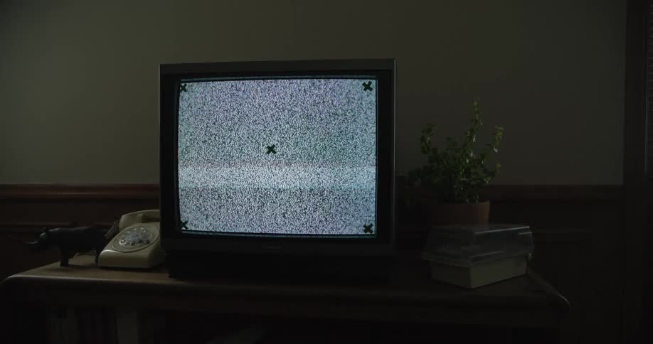 Vintage television with no signal on a table in a room of the house