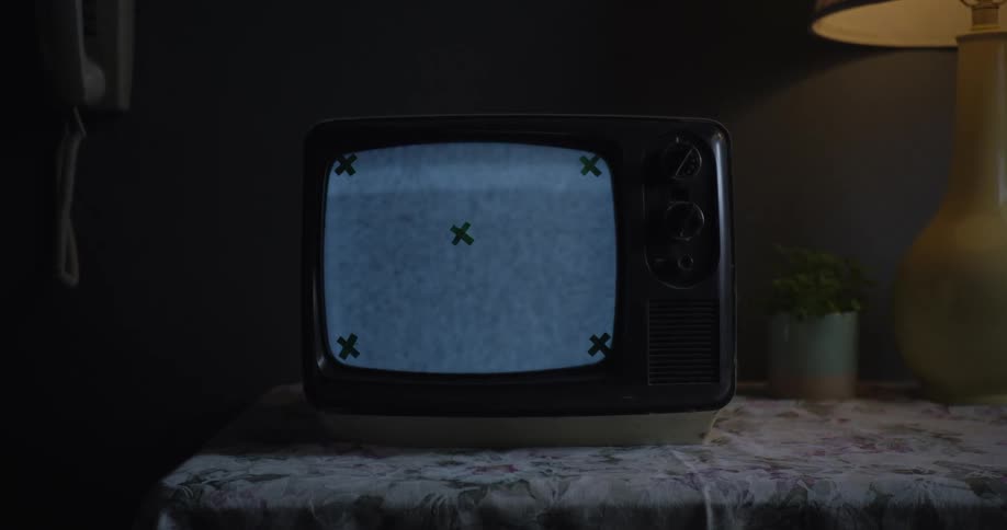 A flickering television is by the lamp