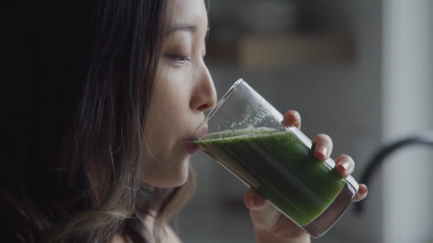 Woman drinking green juice