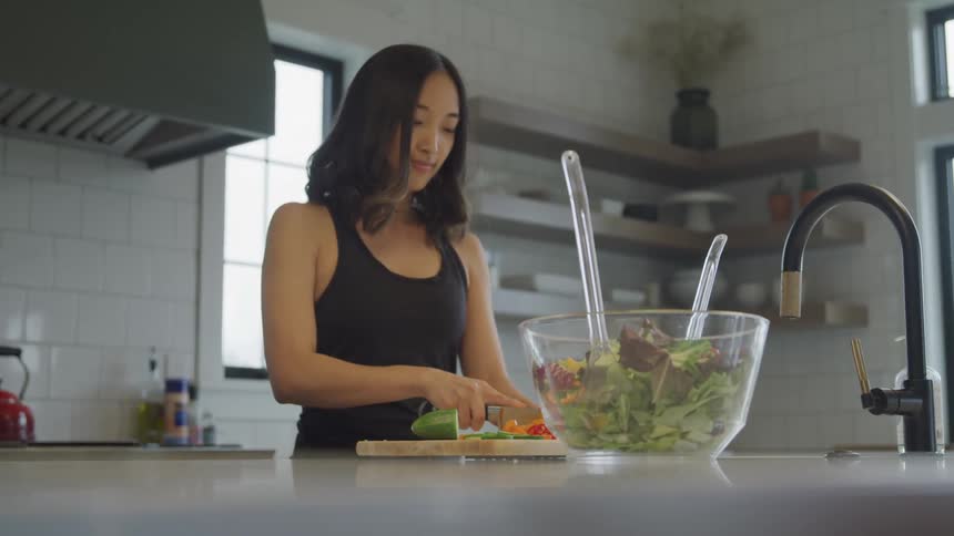Woman in the kitchen cutting vegetables