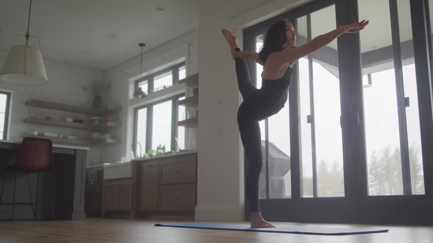 A woman is doing yoga by the doors